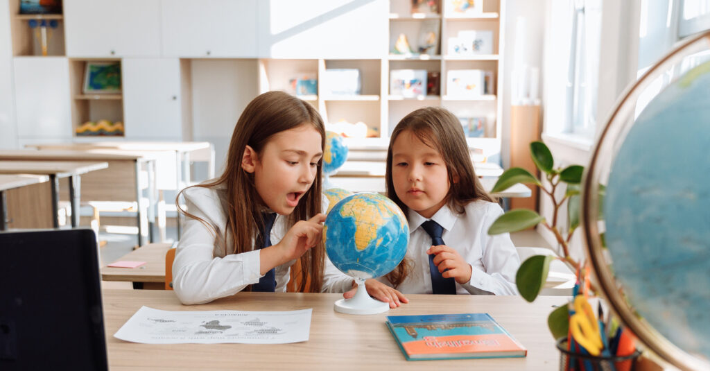 Two students looking at a globe.