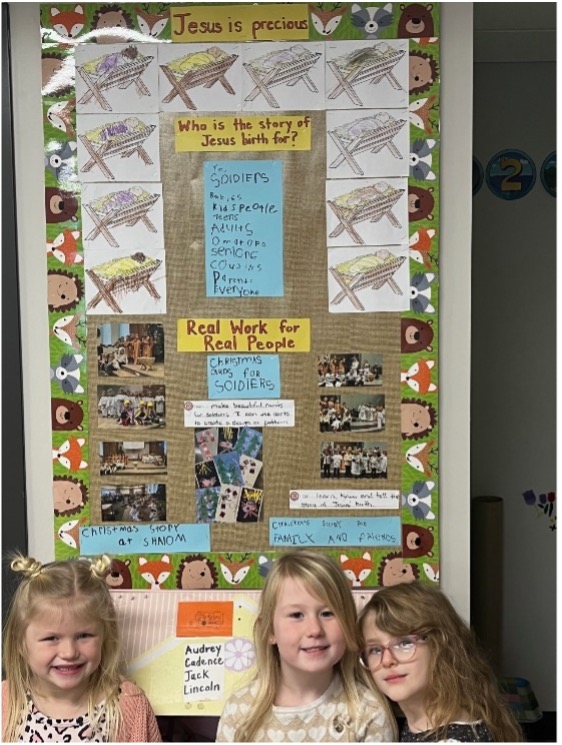 Photo of Kindergarten students showing us their Christmas Cards project for deployed Canadian military personnel.