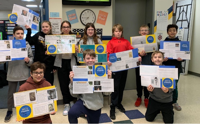WCS students holding their completed "Courageous Explorers" research posters.