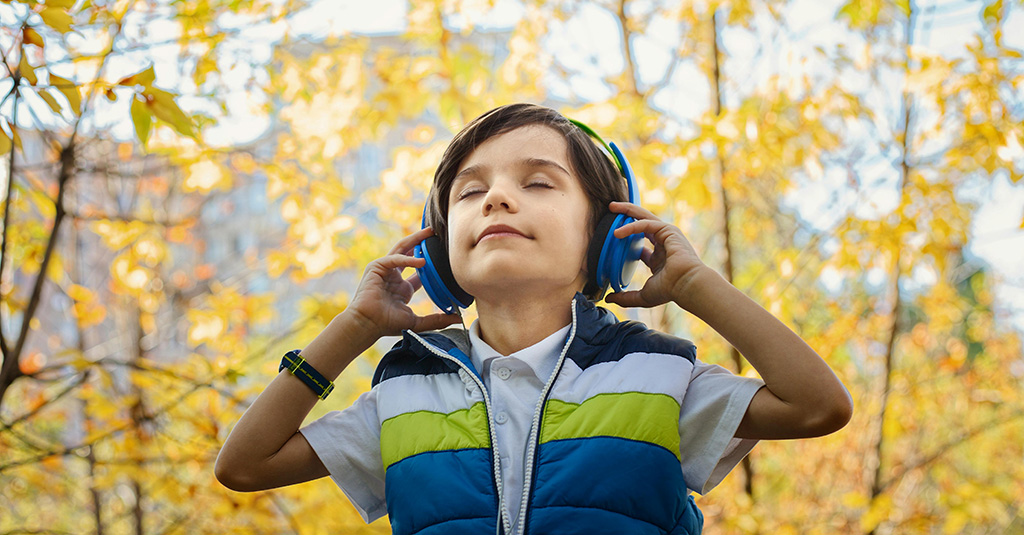 Young student wearing headphones and listening to music.