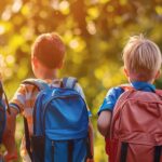 Three kids with backpacks walking in a sunny park, representing friendship, school, and outdoor activities, back view